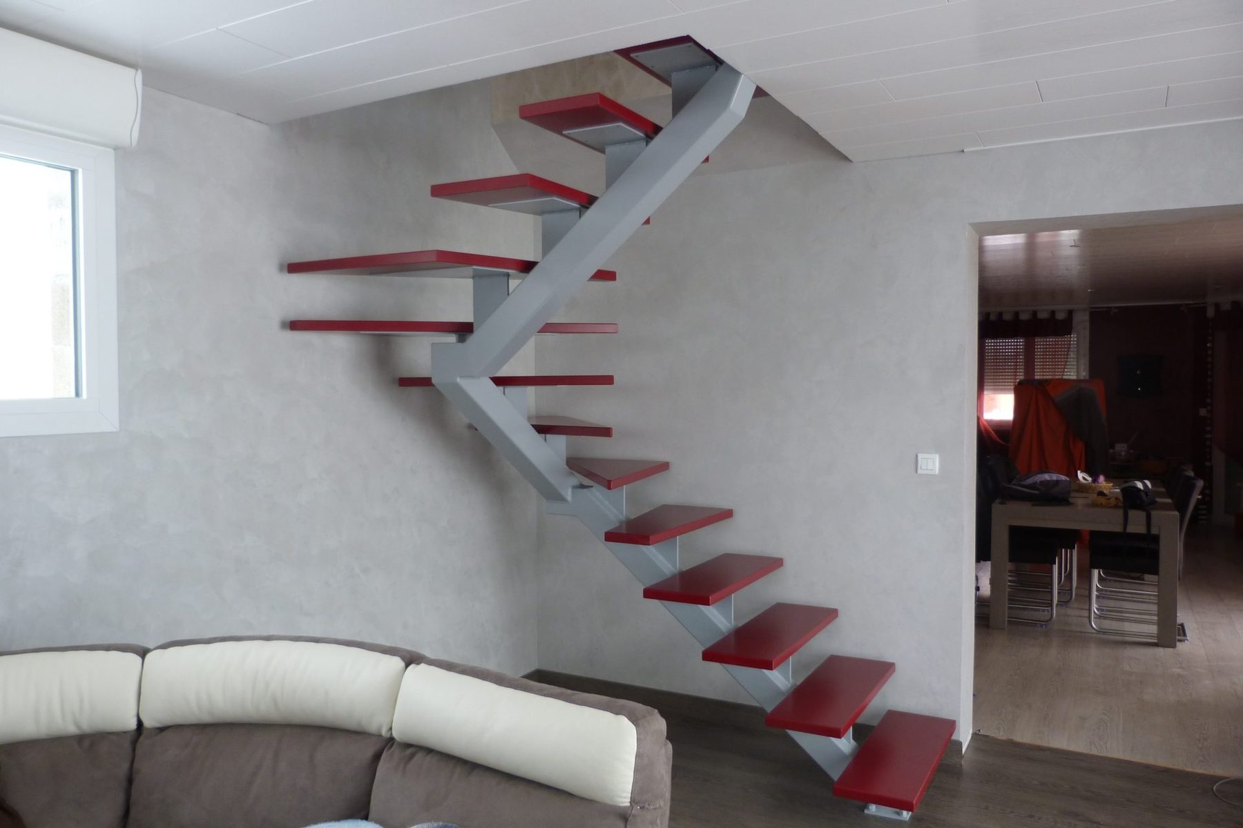 Escalier à limon central métallique gris et marches laquées rouges — vue 1