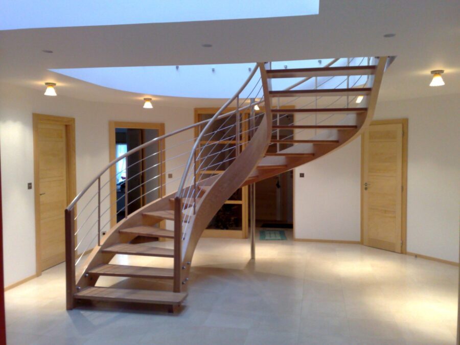 Escalier courbe à limon lamellé-collé dans un grand hall